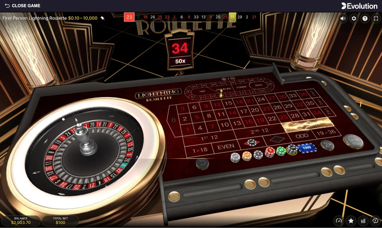 Mid-session at $100 stakes, the full betting layout with a Lightning multiplier card for 34 at 50x lit above the wheel, balance $2,003.70